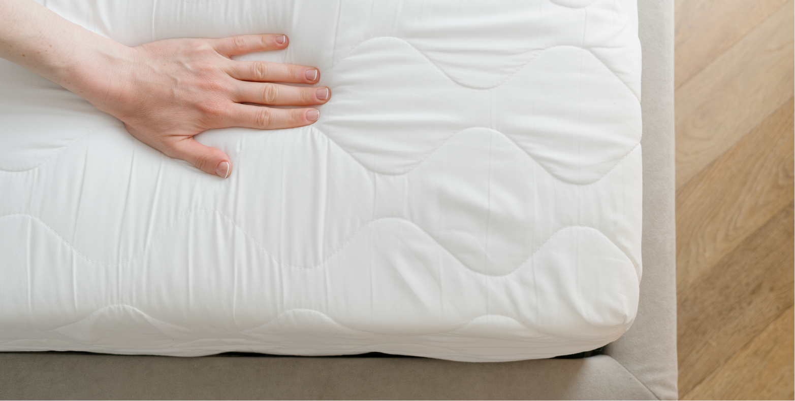 A white memory foam mattress and someone touching it.