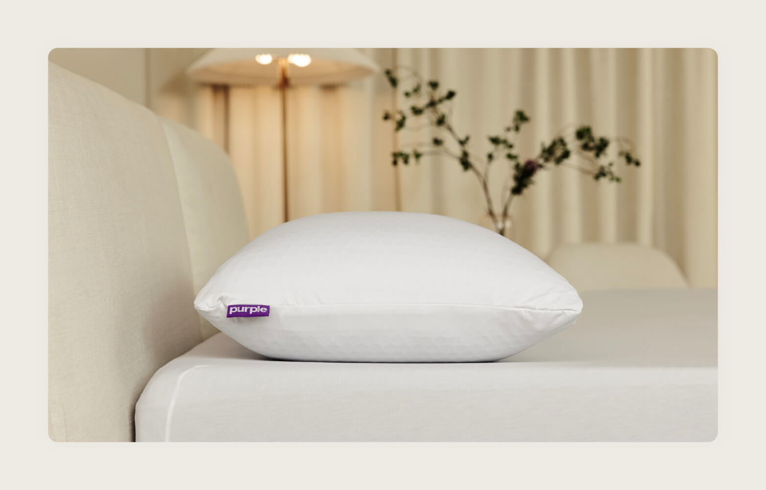 Photo of the  Purple Freeform pillow on top of a neutral bed.