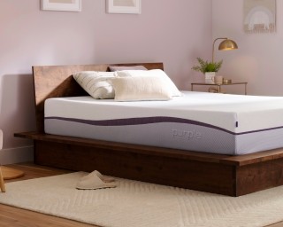 An unmade Purple Plus mattress in a bedroom