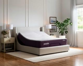 An inclined adjustable bed in a bedroom with bright walls and wood floors accented with bedroom furniture. 