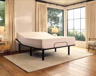 A Purple Adjustable Base elevating the head of a white mattress.