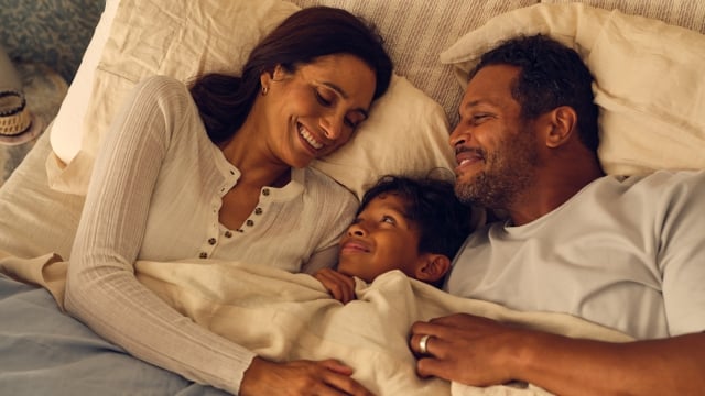 Family cuddling in bed