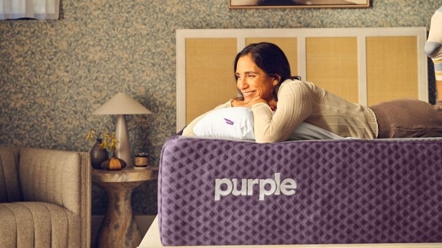 Smiling woman laying on her stomach on mattress