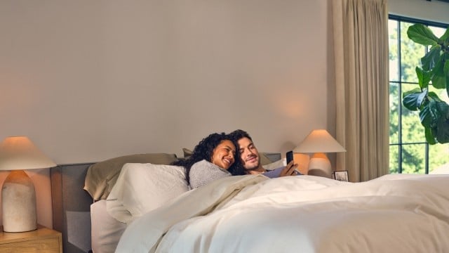 Couple in bed looking at phone 
