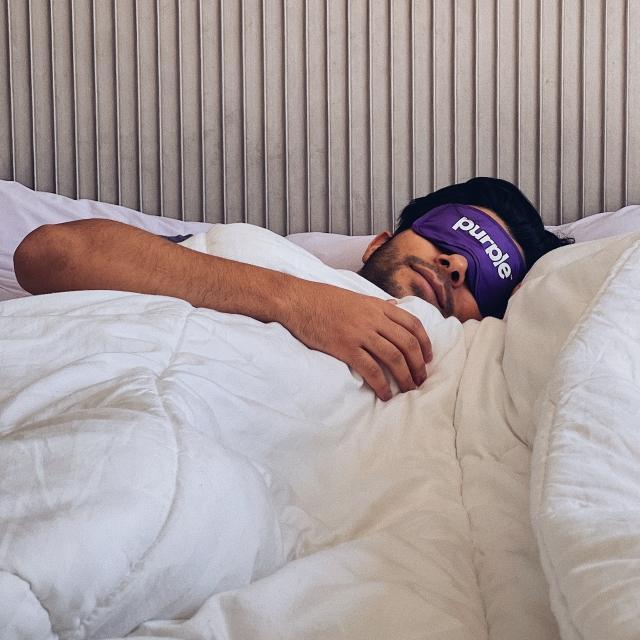 Man Sleeping on Purple Mattress