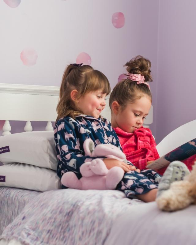 Two girls reading in a Purple Bed