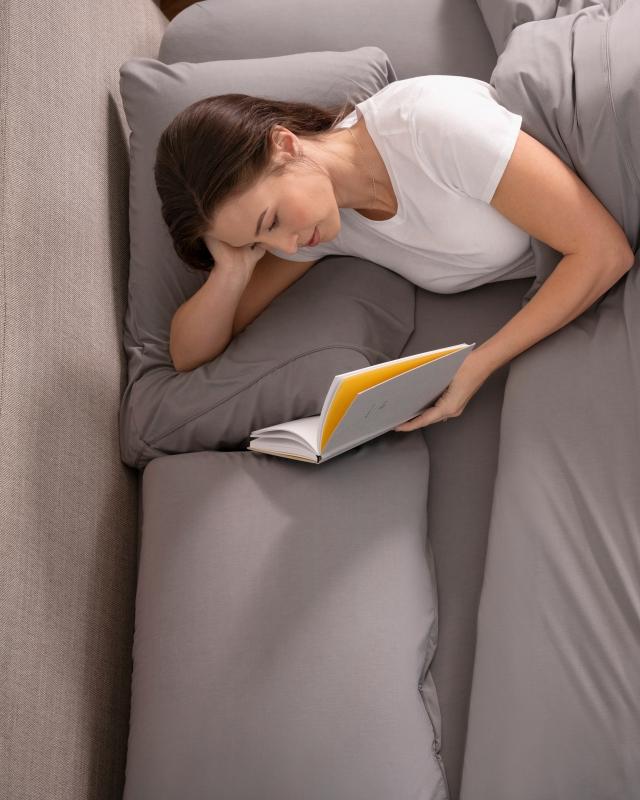Woman reading using duvet