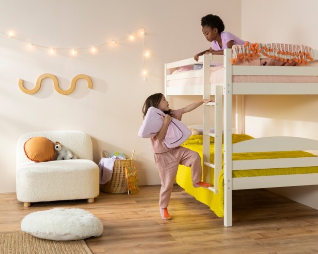 Girl holding pillow climbing onto bunkbed