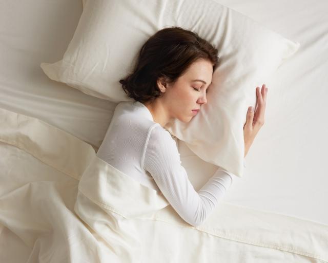 Woman sleeping in white sheets
