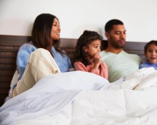 family sitting in bed