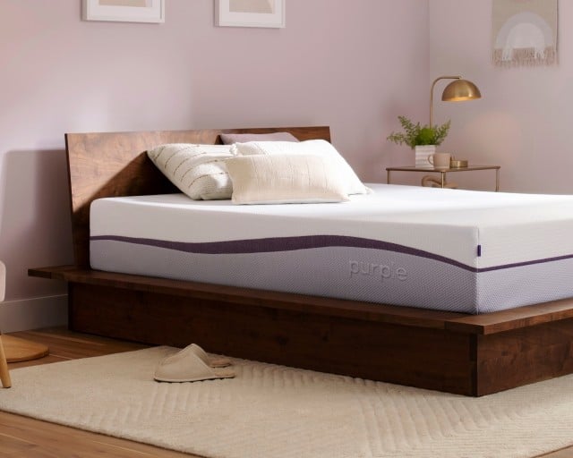 An unmade Purple Plus mattress in a bedroom