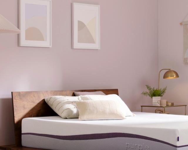 An unmade Purple Plus mattress in a bedroom