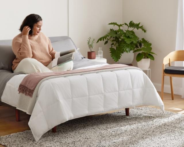 woman laying on mattress studying