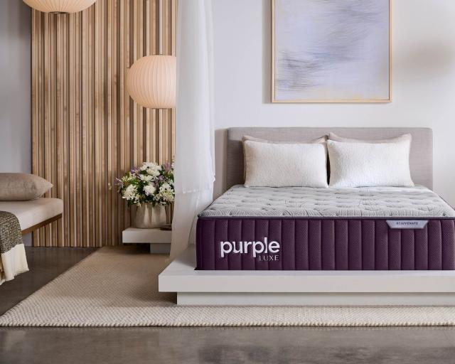 Bedroom with a grey bed frame and a Purple Rejuvenate mattress on top.