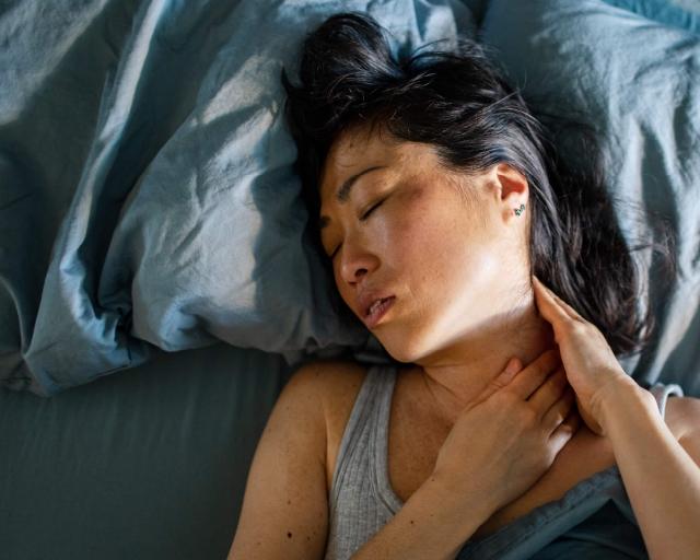 A photo of someone looking uncomfortable sleeping on an old pillow.