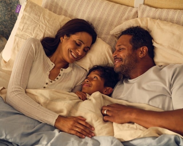 Family cuddling in bed