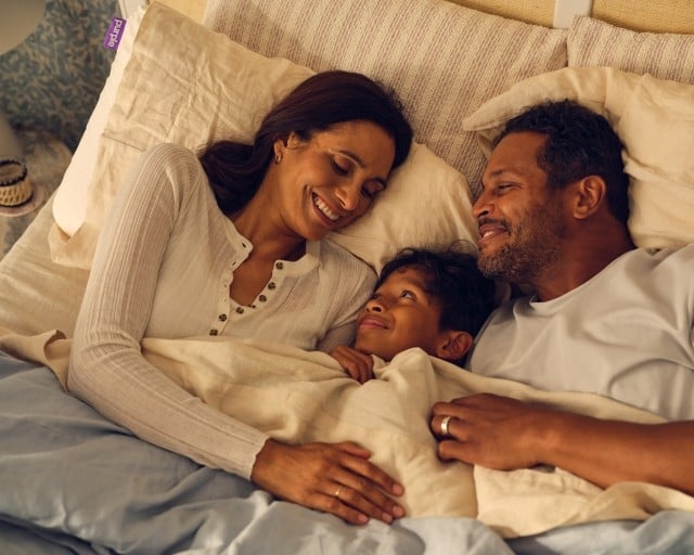 Family cuddling in bed