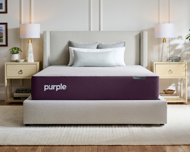 A Restore hybrid mattress on an upholstered bed frame.