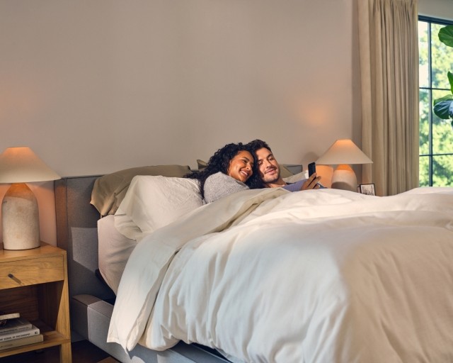 Couple in bed looking at phone 
