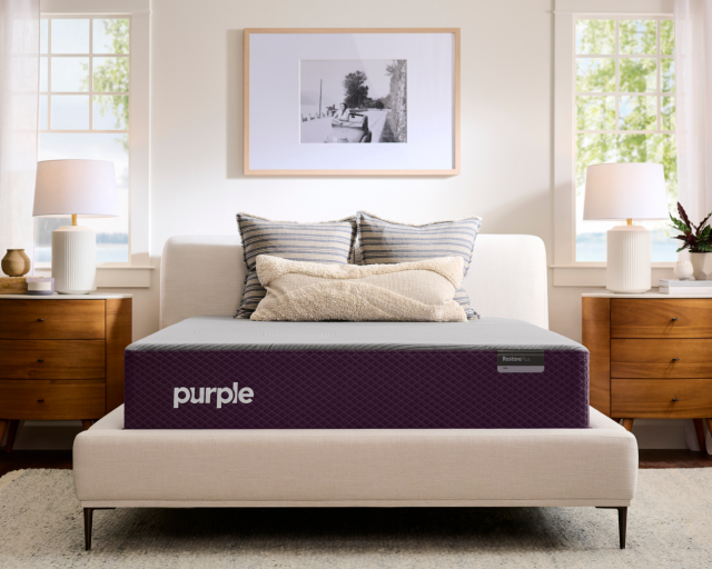 A Purple Restore Hybrid mattress in a well-lit bedroom.