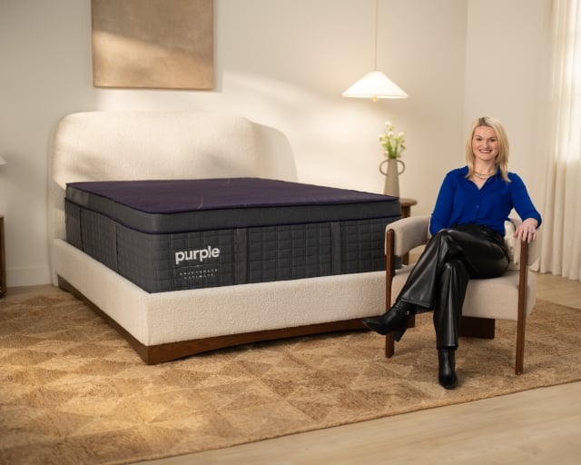 Woman sitting on chair next to RejuvenateUltimate Mattress