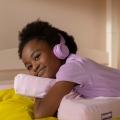 kid hugging kid pillow with headphones on