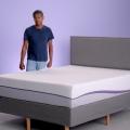 Man standing behind Purple Plus mattress