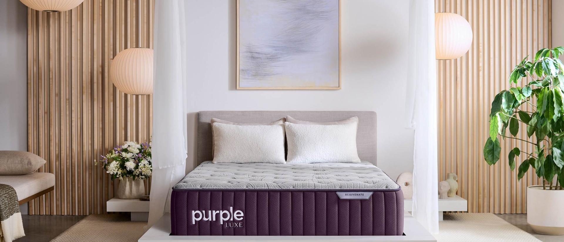 Bedroom with a grey bed frame and a Purple Rejuvenate mattress on top.
