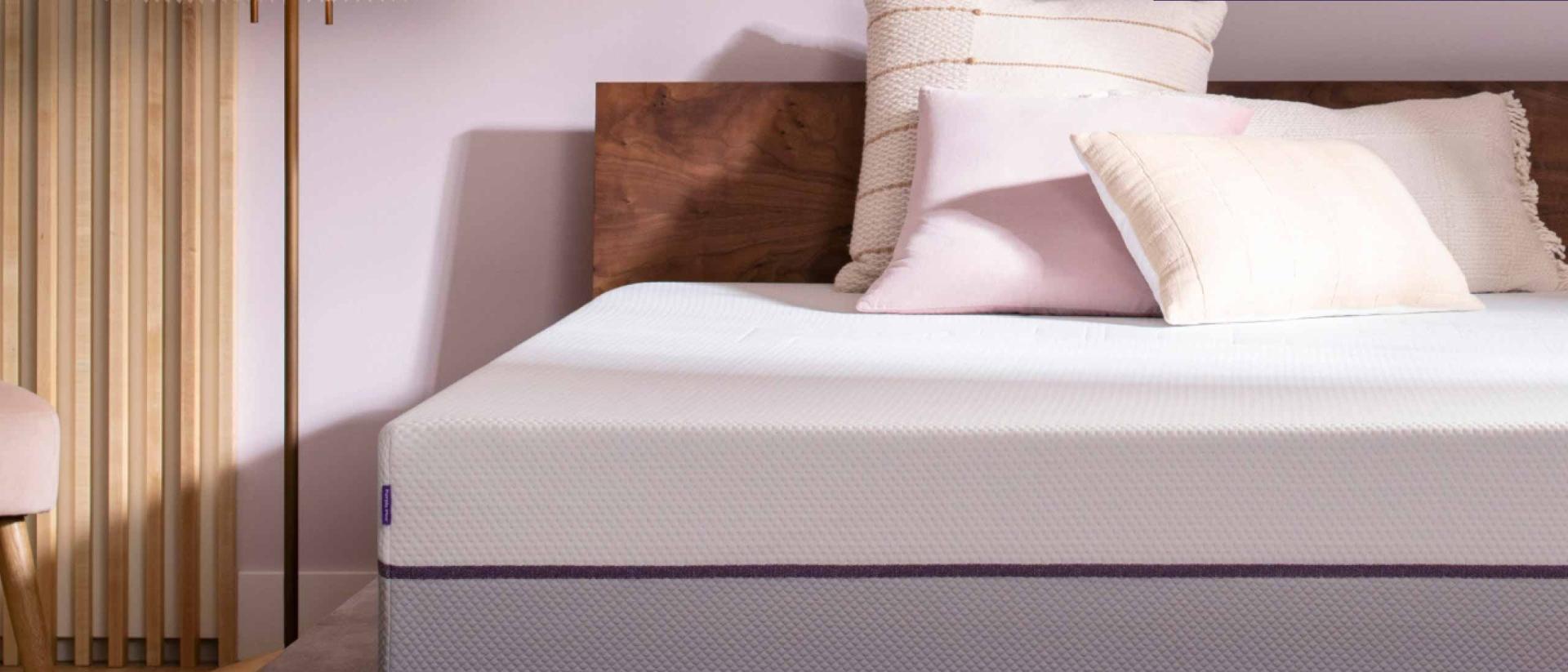 Purple mattress in a dark wood platform bed foundation.