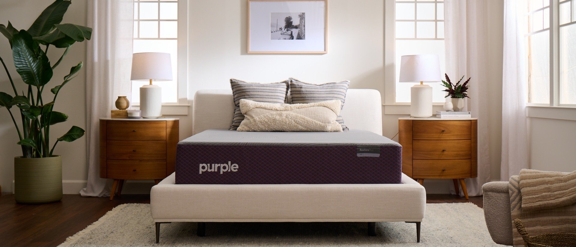 A Purple RestorePlus Hybrid mattress in a well-lit bedroom.