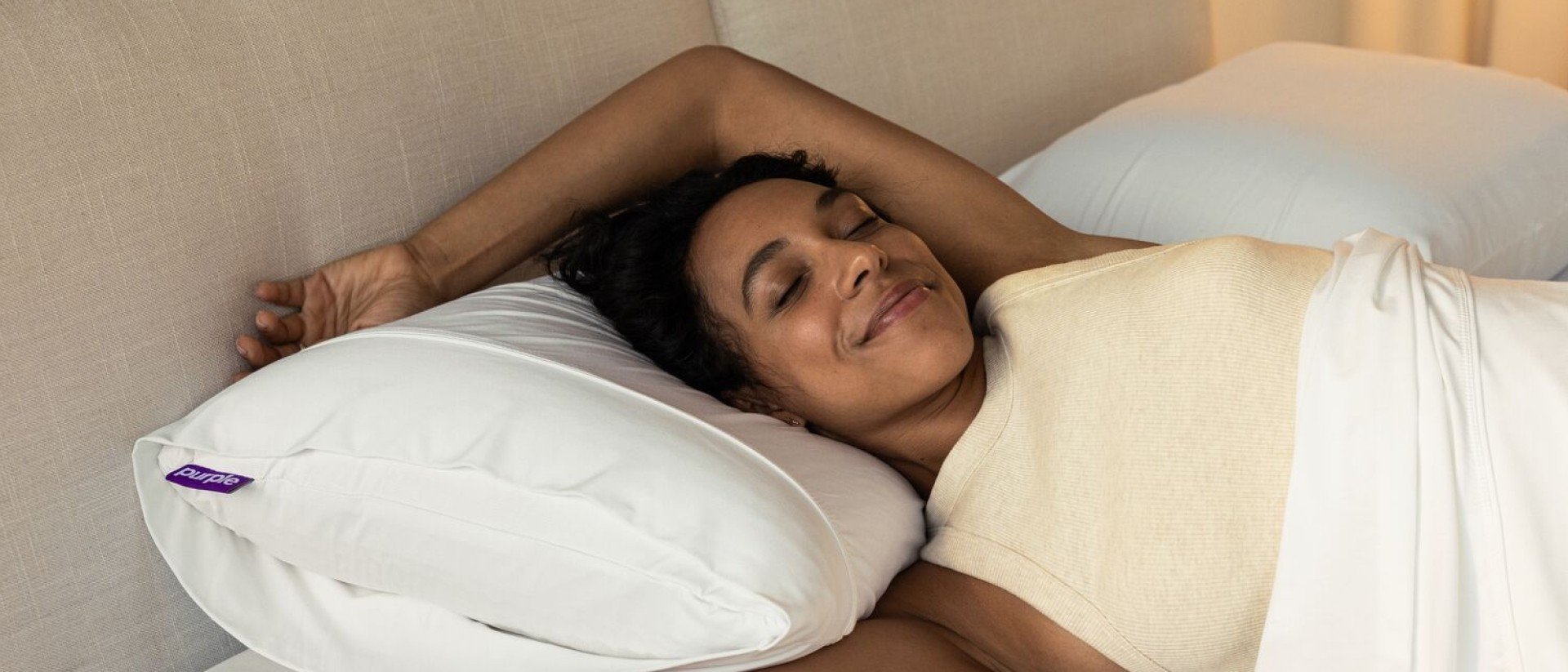 A woman sleeping comfortably on a Purple Harmony pillow.