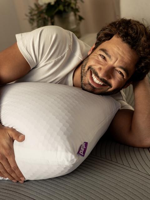 Man snuggling with Freeform pillow